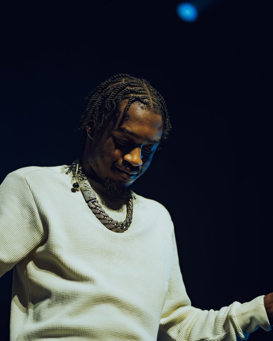 Lil Tjay backstage in a white sweater