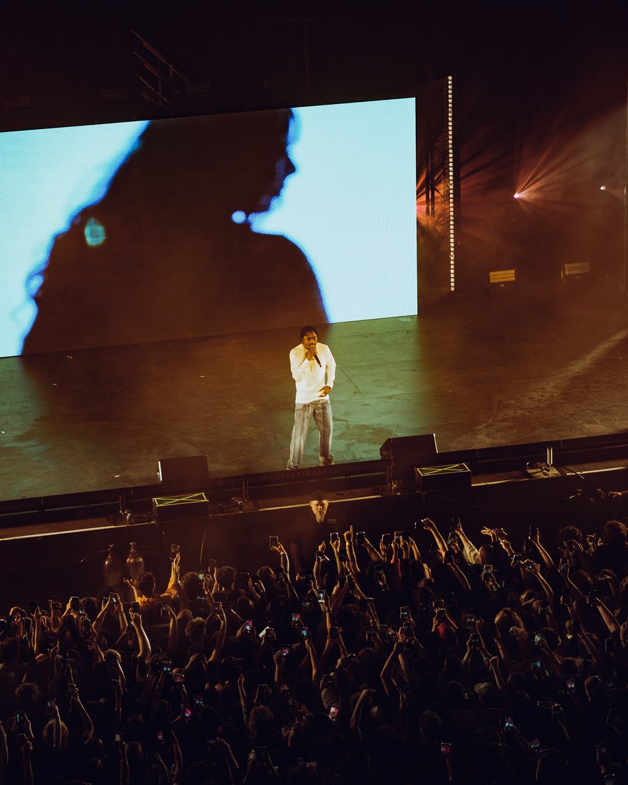 Lil Tjay performing on the arena screen above the crowd